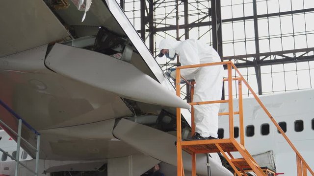 Aircraft service, view of the tail of the aircraft. Repair of an airplane wing white 4k.