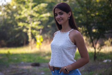 pretty young girl smiling in the park at sunset