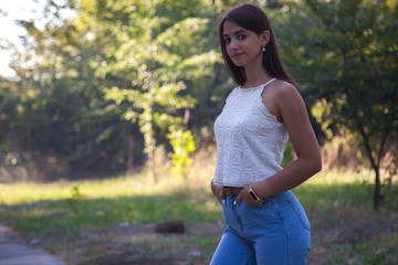 pretty young girl smiling in the park at sunset