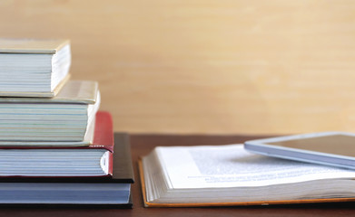 Open textbook and notepad on the table. The concept of combining learning in the past and present.