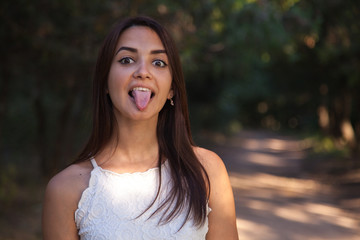 young cute woman showing to standing in the green park