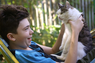 teenager boy with cat in hummock nap