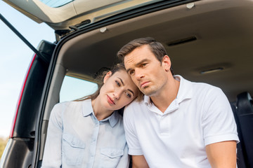 sad adult couple sitting in car together and looking away