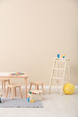 Stylish child's room interior with toys and new furniture, space for text