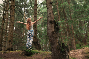 Woman on walk in beautiful coniferous forest