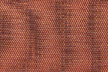 Dark orange textile background with checkered pattern, closeup. Structure of the fabric macro.