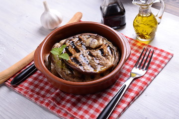 Terracotta bowl with roasted aubergines flavored with vinegar and mint oil 