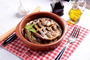 Terracotta bowl with roasted aubergines flavored with vinegar and mint oil 