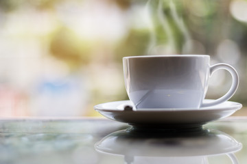 Hot coffee on table in bokeh background