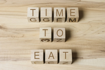 TIME TO EAT text on wooden cubes on wooden background