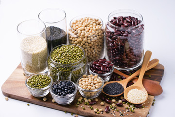 Many nuts and sesame seeds on wooden floor.