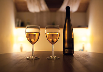 Pair of wine glasses in a restaurant setting. 