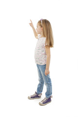 Adorable little girl pointing at wall. Isolated on white background 