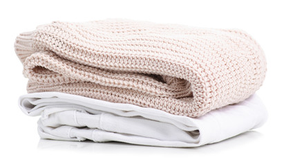 Stack of clothing white jeans and beige sweater on a white background isolation