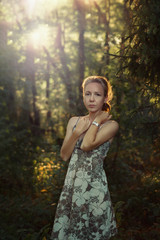 beautiful young woman walking in a park among the trees