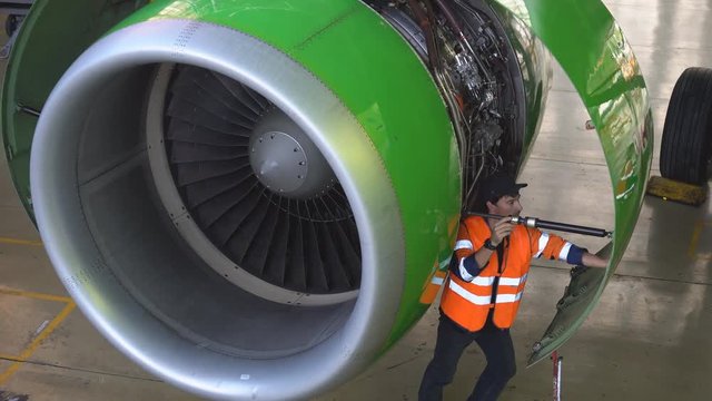 Maintenance of passenger aircraft. Engineer checks the aircraft engine. Aircraft repair in the hangar. Aircraft maintenance. Start the jet engine. 4k