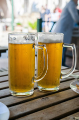 Two glasses of lager served on old wooden planks, copyspace for text