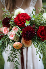 Bride Holding a Bouquet of Red, Maroon, Pink, Peach, and Yellow Flowers - Ranunculus, Roses, Dahlias
