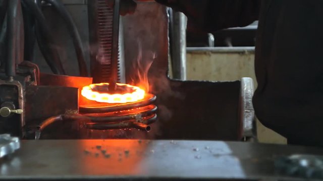Hardening and heat treatment of the metal gear of the part on the equipment for hardening of metal products, heat treatment at the factory, close-up
