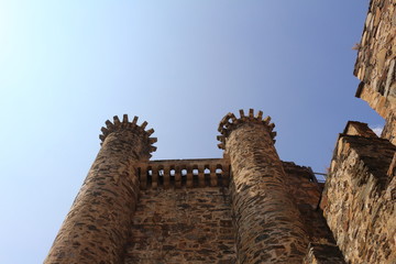 Imponentes torreones de un castillo medieval europeo con el cielo azul detrás