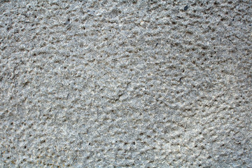 old granite wall with cells, grey color with spots