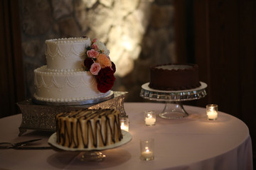 Buttercream Wedding Cake Decorated with White, Pink, and Red Roses on a Silver Cake Stand