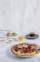 Belgian waffles Slow food breakfast concept figs raspberries honey Espresso coffee white wooden background Horizontal Perspective
