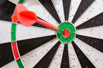 Red dart arrows hitting in the center of dartboard , Shot red dart arrow on center of dartboard