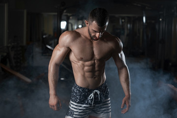 Strong fitness man shows his athletic body in the gym. The concept of a healthy lifestyle