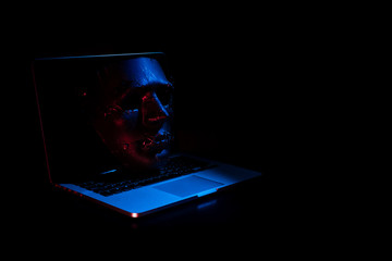 devil mask with computer notebook in hacker security network concept and hologram display red blue