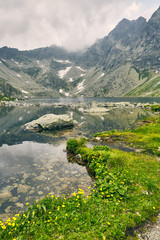 Fototapeta na wymiar Hincovo pleso. Pure lake with a rocky bottom on the background of the mountains of the High Tatras