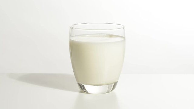 Vaso de leche en la mesa blanca