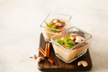 Cashew vegan cake with apple mousse and cinnamon in portion bowls decorated with mint overhead