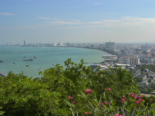 Bay in Thailand in the sea of beautiful turquoise color which merges with the sky, ships and houses in the background