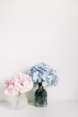 Pink and blue hydrangea flower bouquets on white background. Minimal interior design floral concept.