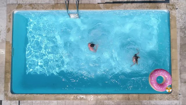 Aerial - Couple Jumping In The Pool At The Same Time Like A Cannon Ball