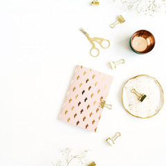 Gold styled home workspace with notebook, scissors and clips on white background. Flat lay, top view.