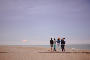 group of people doing exercises at sunrise meet the sun, doing yoga, a healthy lifestyle