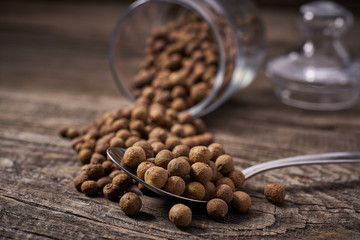 Dried allspice in a metal spoon close-up