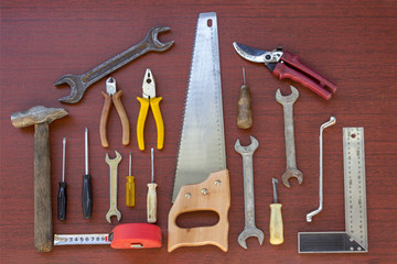 Man's tools composition on the table. Handyman instruments in house shaped form with wooden background