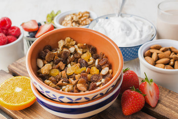 Healthy eating, paleo gluten free nut and fruit granola served with fruits and berries, nut milk, coconut yogurt, selective focus