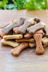 Dog tasty colored biscuits on wooden background 