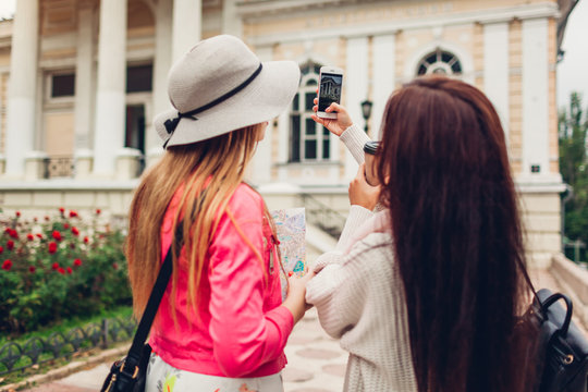 Two women tourists taking picture of architecture in Odessa. Happy friends travelers going sightseeing