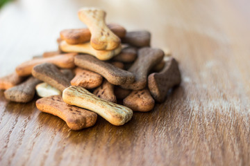 Dog tasty colored biscuits on wooden background 