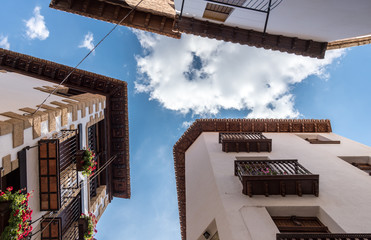 Wooden eaves of houses nearby in an old village of Spain, carved wood carving low angle shooting blue sky and clouds views, traditional architecture building