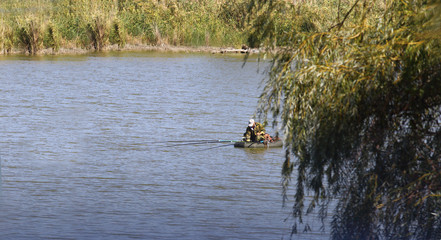 An angler on the lake in a nice summer warm day ...