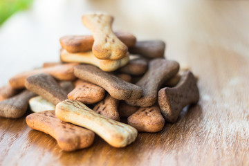 Dog tasty colored biscuits on wooden background 