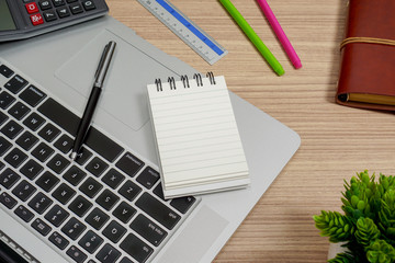 Notebook and laptop on wood working desk. Text copy space.