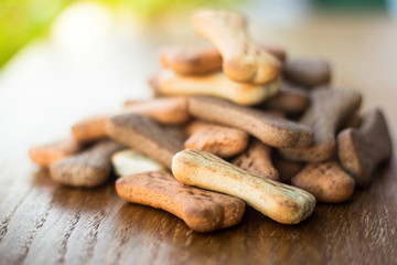 Dog tasty colored biscuits on wooden background 