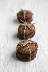 Chocolate chip cookies on a white wooden background, side view. Selective focus.